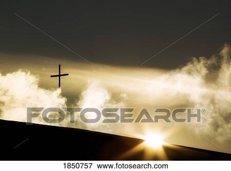 Stock Photo - The cross on a hilltop with the sunrise. Fotosearch