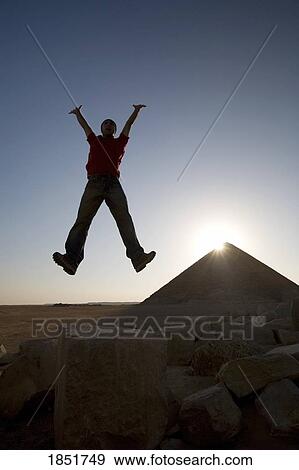 Stock Photo - The Red Pyramid, Dahshur necropolis, Egypt; man jumping in front of pyramid. Fotosearch