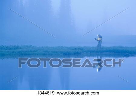 Stock Photo - Tipso Lake, Mount Rainier National Park, Washington State, USA; Hiker reading a map. Fotosearch