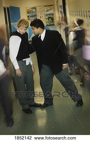 Stock Image - Two teenage boys; Bullying at school. Fotosearch