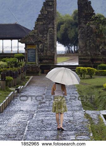 Ulun Danu Bratan Temple, Bali, Indonesia; Woman walking with umbrella View Large Photo Image Stock Photography - Ulun Danu Bratan Temple, Bali, Indonesia; Woman walking with umbrella. Fotosearch