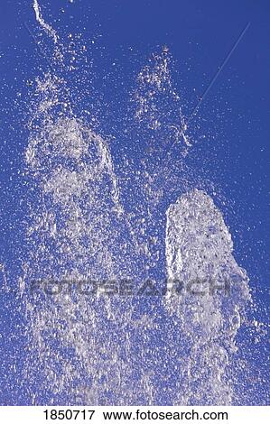 Stock Photo - Water spouting into air against blue sky . Fotosearch