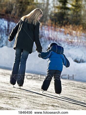 Stock Photograph - Woman and child; Mother skating with son. Fotosearch