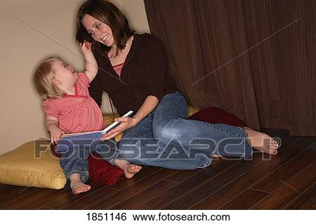 Woman and girl; Mother and daughter reading together View Large Photo Image Stock Photograph - Woman and girl; Mother and daughter reading together. Fotosearch