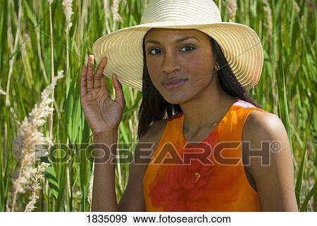 Stock Photo - Woman in hat in tall grass . Fotosearch