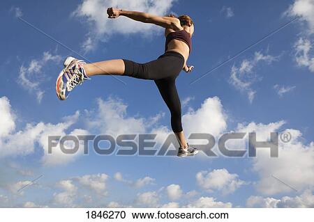 Stock Image - Woman jumping in midair . Fotosearch