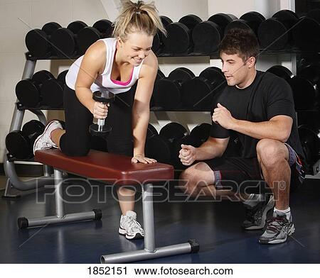 Woman lifting weights with a trainer View Large Photo Image Stock Image - Woman lifting weights with a trainer. Fotosearch