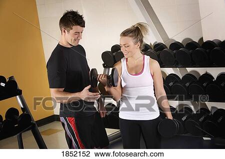 Woman lifting weights with a trainer View Large Photo Image Stock Image - Woman lifting weights with a trainer. Fotosearch