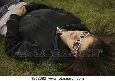Stock Image - Woman lying on the grass. Fotosearch