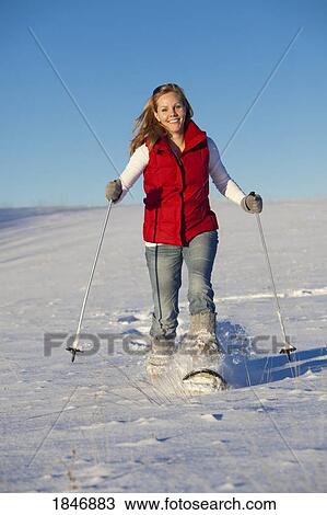 Stock Image - Woman snowshoeing. Fotosearch