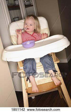 Stock Image - Young girl in a high chair. Fotosearch