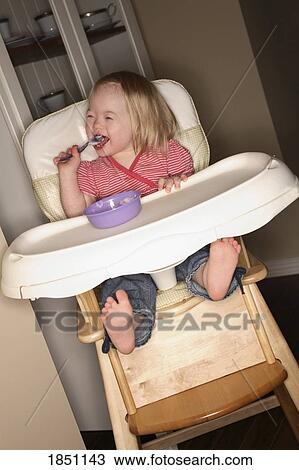 Young girl in a high chair View Large Photo Image Stock Image - Young girl in a high chair. Fotosearch