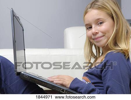 Stock Image - Young girl on a lap top. Fotosearch
