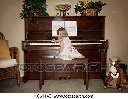 Stock Photo - Young girl playing the piano. Fotosearch