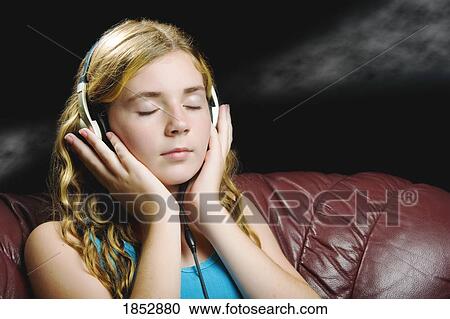 Young girl; Young girl listening to music on her headphones View Large Photo Image Stock Image - Young girl; Young girl listening to music on her headphones. Fotosearch