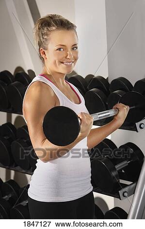Young woman lifting weights View Large Photo Image Stock Photo - Young woman lifting weights. Fotosearch