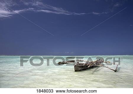 Stock Image - Zanzibar, Tanzania; Dhow in shallow water. Fotosearch