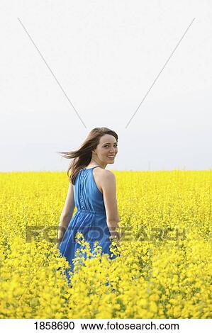 Stock Image - A young woman in a canola field. Fotosearch