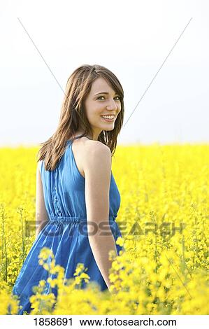 A young woman in a canola field View Large Photo Image Stock Image - A young woman in a canola field. Fotosearch