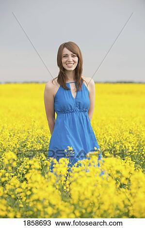 Stock Image - A young woman in a canola field. Fotosearch