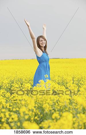 A young woman in a canola field View Large Photo Image Stock Photograph - A young woman in a canola field. Fotosearch