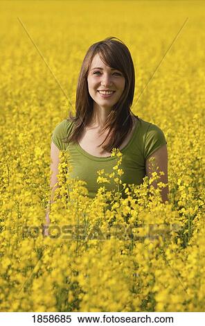 Stock Photography - A young woman in a canola field. Fotosearch