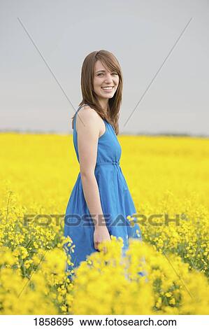 Stock Photography - A young woman in a canola field. Fotosearch