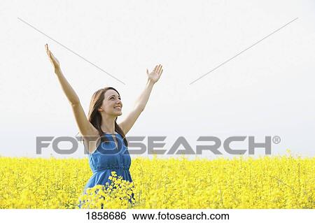 Stock Photograph - A young woman with arms raised. Fotosearch
