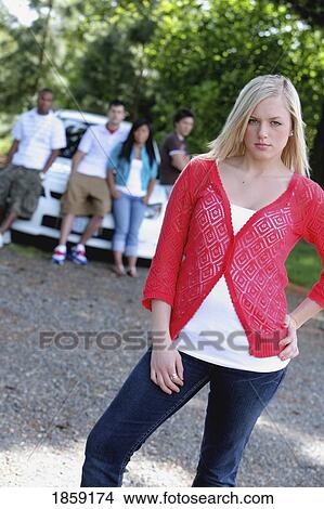 Picture - Angry woman standing separate from her friends. Fotosearch