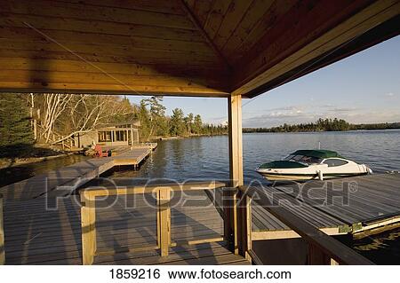 Stock Photograph - Boat and dock, Lake of the Woods, Ontario, Canada. Fotosearch