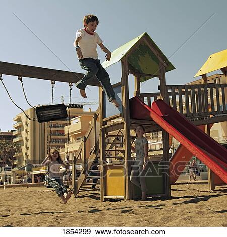 Stock Photo - Boy jumping off a swing at the playground. Fotosearch