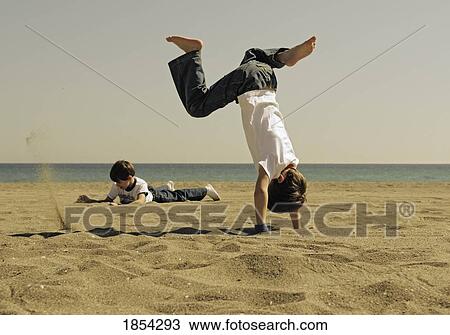 Stock Image - Boys playing in the sand. Fotosearch