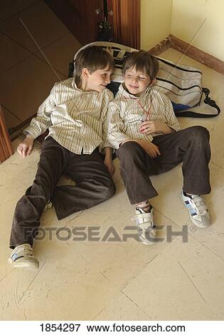 Brothers laying on the floor View Large Photo Image Stock Photo - Brothers laying on the floor. Fotosearch