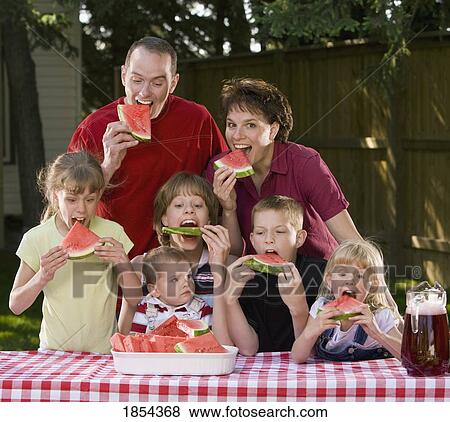 Stock Photo - Family eating watermelon. Fotosearch