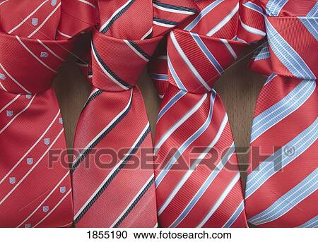 Stock Image - Four knotted red ties in a row. Fotosearch