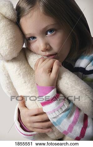 Stock Image - Girl hugging teddy bear. Fotosearch