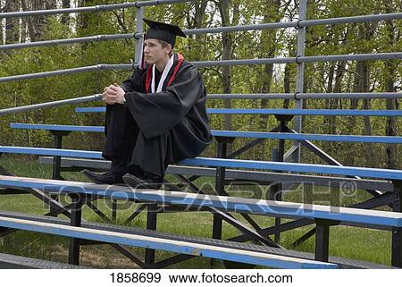 Graduate sitting on bleachers View Large Photo Image Stock Photo - Graduate sitting on bleachers. Fotosearch