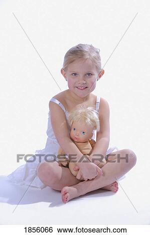 Stock Photograph - Little ballerina sitting with her doll. Fotosearch