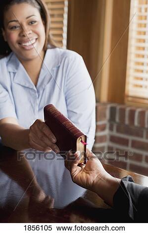 Man passing Bible to woman View Large Photo Image Stock Photography - Man passing Bible to woman. Fotosearch