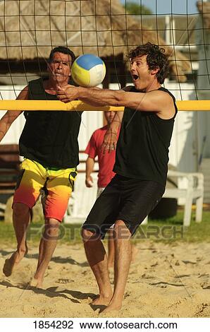 Men playing beach volleyball View Large Photo Image Stock Image - Men playing beach volleyball. Fotosearch