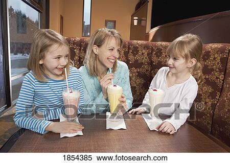 Stock Photography - Mother and daughters have milkshakes. Fotosearch