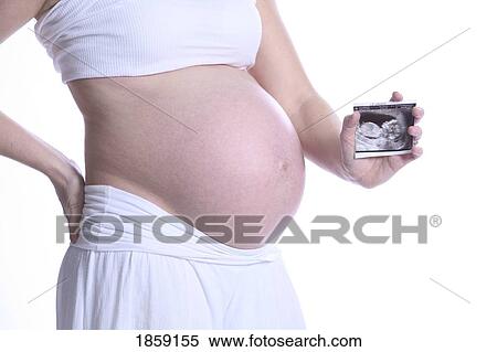 Stock Photography - Pregnant mom holding ultrasound photo. Fotosearch