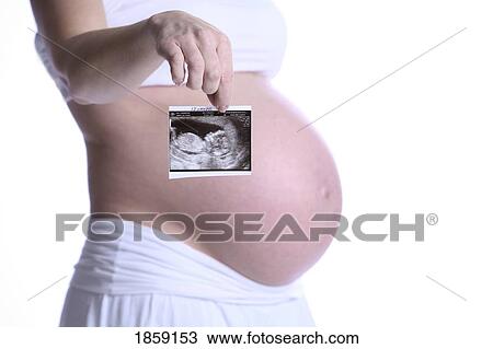 Stock Image - Pregnant mother holding a photo of baby. Fotosearch