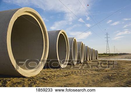Stock Image - Sewer pipes ready to be installed in highway. Fotosearch