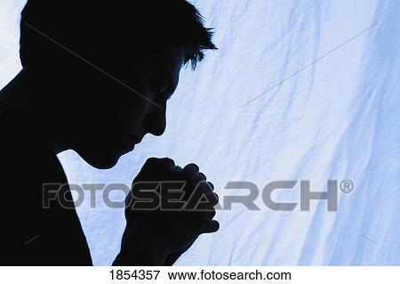Stock Photo - Silhouette of a man praying. Fotosearch