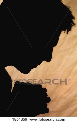 Stock Photo - Silhouette of man praying. Fotosearch