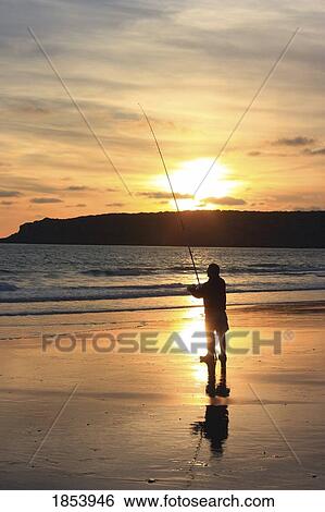 Silhouette of person fishing on a beach View Large Photo Image Stock Photograph - Silhouette of person fishing on a beach. Fotosearch