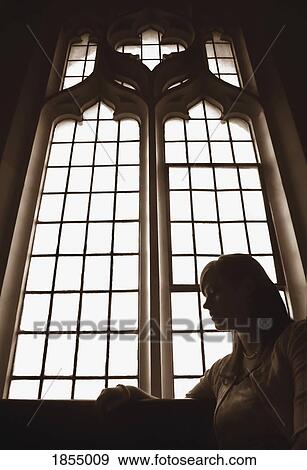Silhouette of woman in front of church window View Large Photo Image Stock Photo - Silhouette of woman in front of church window. Fotosearch