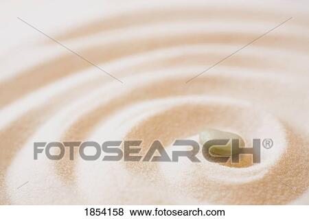 Stock Photo - Single pebble in sand. Fotosearch