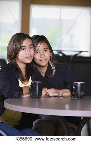 Two girls sitting together View Large Photo Image Stock Image - Two girls sitting together. Fotosearch